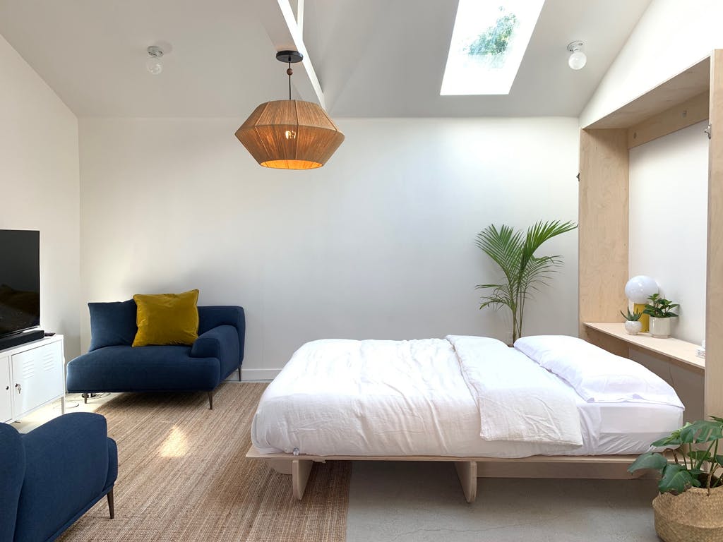 bedroom with a minimalistic design. Clear murphy bed with white bedsheets