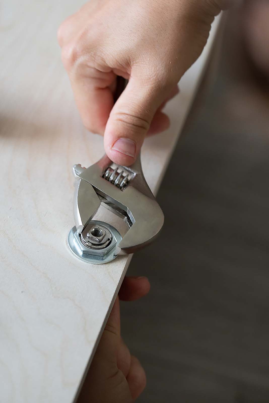 Using an adjustable wrench to assemble a Murphy bed